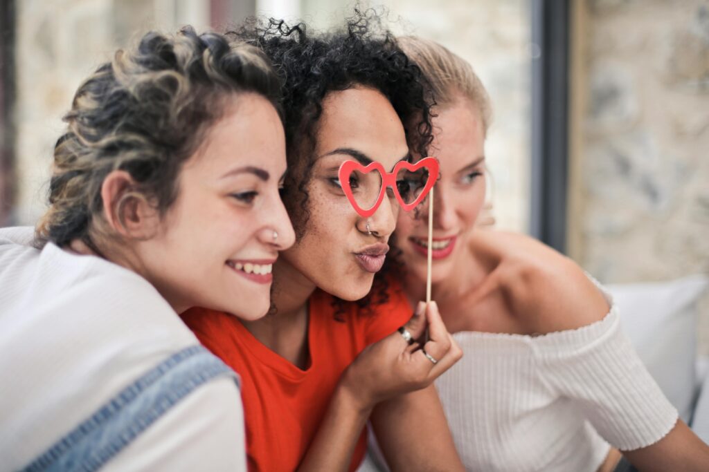 pexels-photo-1524105-1524105 Three women enjoying a playful moment with heart-shaped glasses, symbolizing friendship and fun.
